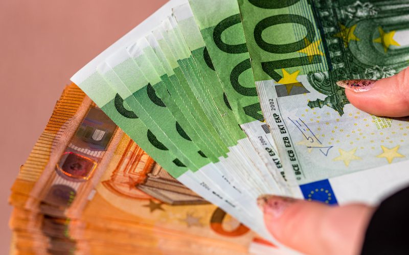 A closeup of female hands counting Euro banknotes